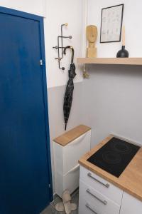 KriževciApartment City Cat的厨房设有蓝色的门,墙上配有雨伞