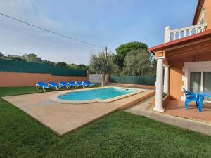 卡隆赫Costa Brava Suites Villa Cèsar的一个带蓝色椅子的游泳池