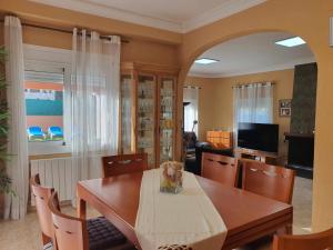 卡隆赫Costa Brava Suites Villa Cèsar的一间带木桌和椅子的用餐室
