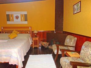 维奥康德马奥Hotel Cantinho de Férias的配有一张床和一把椅子的酒店客房