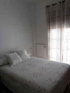 埃尔罗西奥Mini Rocio的白色的卧室配有白色床单和窗户