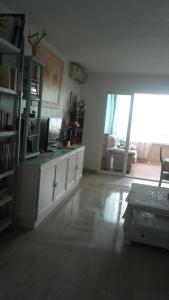 坎佩略Apartamento playa Muchavista的客厅设有书架和书桌