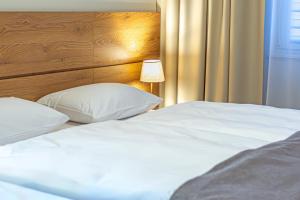 绿山城NOVY Hotel的一间卧室配有两张白色的床和木制床头板