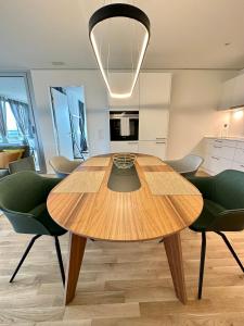 诺伊豪森3.5Room@MydiHei Apartments的厨房配有一张木桌和绿色椅子