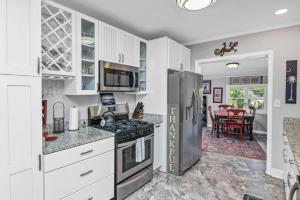 哥伦比亚2BR Cottage - Minutes from USC的厨房配有白色橱柜和不锈钢冰箱