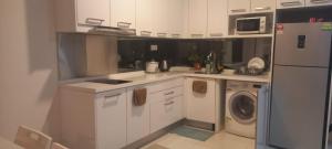 吉隆坡CUSHY DORM at KLCC的厨房配有白色橱柜、洗衣机和烘干机