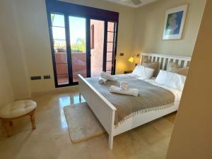 奥亨Picasso apartment in El Soto de La Mairena的卧室配有白色的床和毛巾