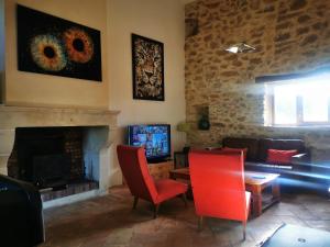 瓦隆蓬达克Bastide du Barry - Centre historique de Vallon Pont d'arc的客厅配有红色椅子和壁炉