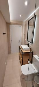 达西亚Casa Sofia的一间带卫生间、水槽和镜子的浴室