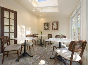 圣巴巴拉De La Vina Inn的客房设有桌椅和窗户。