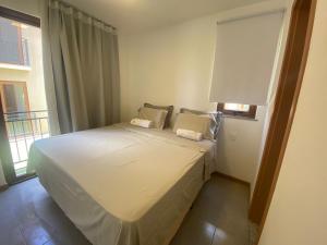 穆库热Vila beija-flor prime / apt 02的卧室配有白色的床和窗户