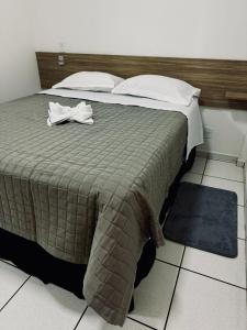 弗朗西斯科贝尔特朗PORTAL PARQUE HOTEL的一间卧室配有一张床,床上有浴袍