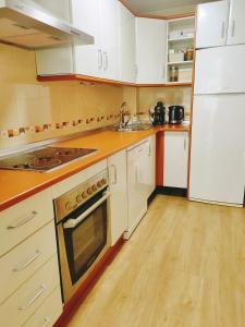 拉斯加比亚斯Salma的铺有木地板的厨房配有白色家电