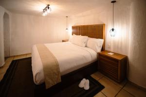 巴耶德布拉沃BOTANIQ HOTEL BOUTIQUE的一间卧室配有带白色床单和枕头的床。