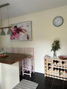 卡文The Lodge-Cozy and serene home的厨房配有桌子和墙上的时钟