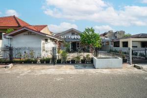 巴东SUPER OYO Gandaria Guest House Near Masjid Raya Sumatera Barat的房屋前方的铁艺围栏