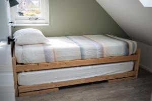 阿赫特克克Holidayhome BB 17 a.的一间卧室配有一张带白色床单的床和一扇窗户。