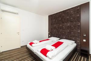 希贝尼克ParkCity rooms的一间卧室配有一张大床,提供红色和白色的毛巾