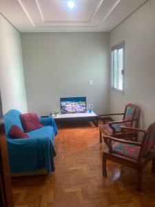 帕苏丰杜Apartamento em Passo Fundo的客厅配有蓝色的沙发和两把椅子