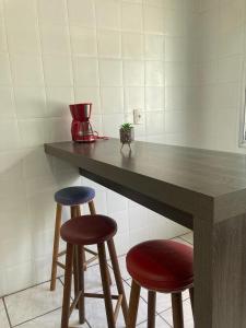 帕苏丰杜Apartamento em Passo Fundo的厨房配有2张凳子和带桌子的柜台。