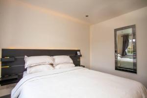 布拉克内尔Three Bedroom House, Driveway, Bracknell Centre的卧室配有一张带镜子的白色大床