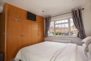 布拉克内尔Three Bedroom House, Driveway, Bracknell Centre的卧室配有白色的床和窗户。