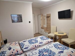 比克Hajnalka vendégház的客房设有1张床、1张桌子和1台电视。