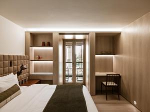 圣保罗Pulso Hotel Faria Lima的一间卧室配有一张床、一张桌子和一把椅子