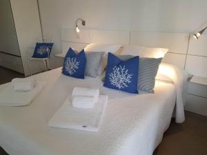 拉古萨码头Lo Scalo 2.0的一张带蓝色枕头的白色床和毛巾
