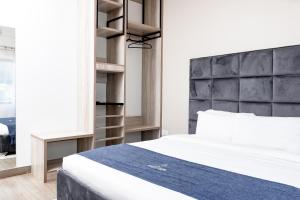 利隆圭The Forty Four Hotel的卧室配有白色的床和黑色床头板