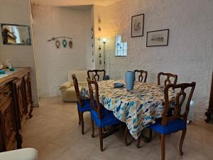 佩拉La terrazza sul lago的一间带蓝椅和桌子的用餐室以及一间厨房