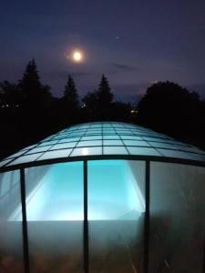桑格豪森Ferienhaus Buchengrund mit eigenem beheizten Pool und Gegenstromanlage的夜空建筑顶部的蓝色灯光