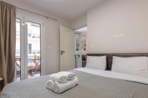 雅典Athenian boutique apartments的一间卧室配有带毛巾的床