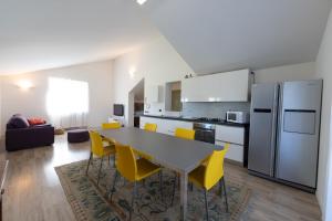 阿萨哥Casa Vecchia Quercia的厨房以及带桌子和黄色椅子的用餐室。