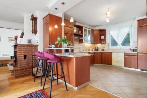波尔托罗ARIA Superior Apartment, Seaview & Wellness的厨房配有木制橱柜和紫色的酒吧凳子