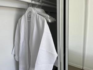 棕榈泉Super Cute room in Architectural Home的壁橱上挂在架子上的白色长袍