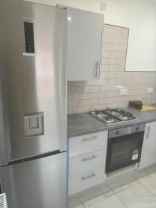 曼彻斯特En-suit double bedroom with bathroom in Manchester的厨房配有不锈钢冰箱和炉灶。