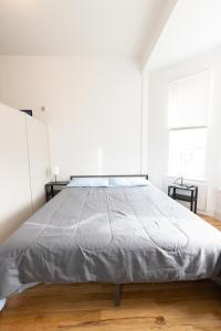 联城Close to NYC - Stylish Modern Studio的白色客房内的一张大床,配有两张桌子