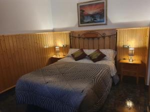 代尔特布雷Casa Roseta的一间卧室配有一张大床,桌子上放着两盏灯