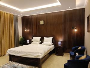 穆里Royal Resort的一间卧室配有一张大床和两把椅子