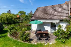 克吕茨Ferienhaus Teichblick的一个带桌子和遮阳伞的庭院