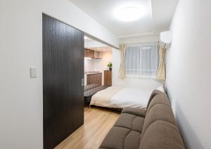东京Repure Omori Residence - Vacation STAY 16383的客厅配有沙发和1张床