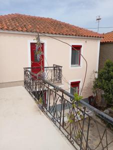 KarpásionKarpasi House的白色的房子,设有红色的门和阳台