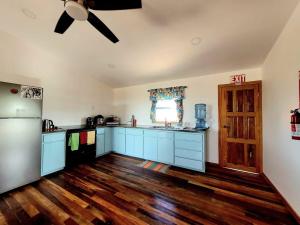 圣佩德罗K'onjo Bet (Beautiful House) @ Secret Beach的厨房配有蓝色橱柜和吊扇