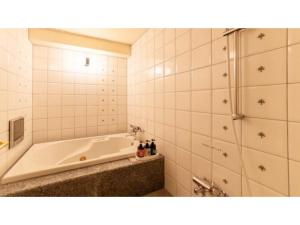 雫石町SHIZUKUISHI RESORT HOTEL - Vacation STAY 29552v的白色的浴室设有浴缸和淋浴。