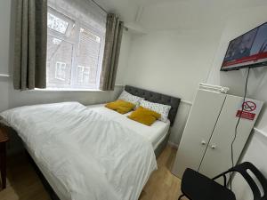 布罗姆利Cosy Smart/Small Double Room in Keedonwood Road Bromley的一间小卧室,配有一张带黄色枕头的床