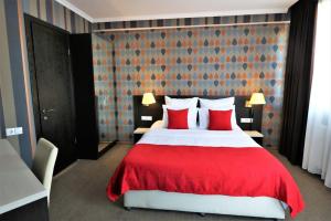 第比利斯East Gate Boutique Hotel的一间卧室配有一张带红色枕头的大床