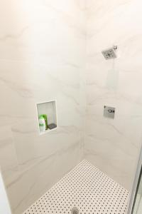 巴约讷Chic 2-Bed Getaway Home-mins to NYC的浴室设有白色墙壁和白色瓷砖,配有淋浴。