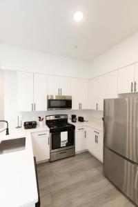 巴约讷Chic 2-Bed Getaway Home-mins to NYC的厨房配有白色橱柜和不锈钢冰箱