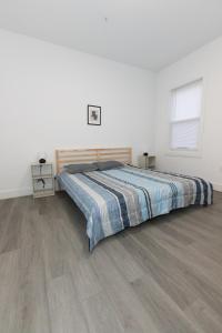 巴约讷Chic 2-Bed Getaway Home-mins to NYC的一间卧室配有一张床,铺有木地板